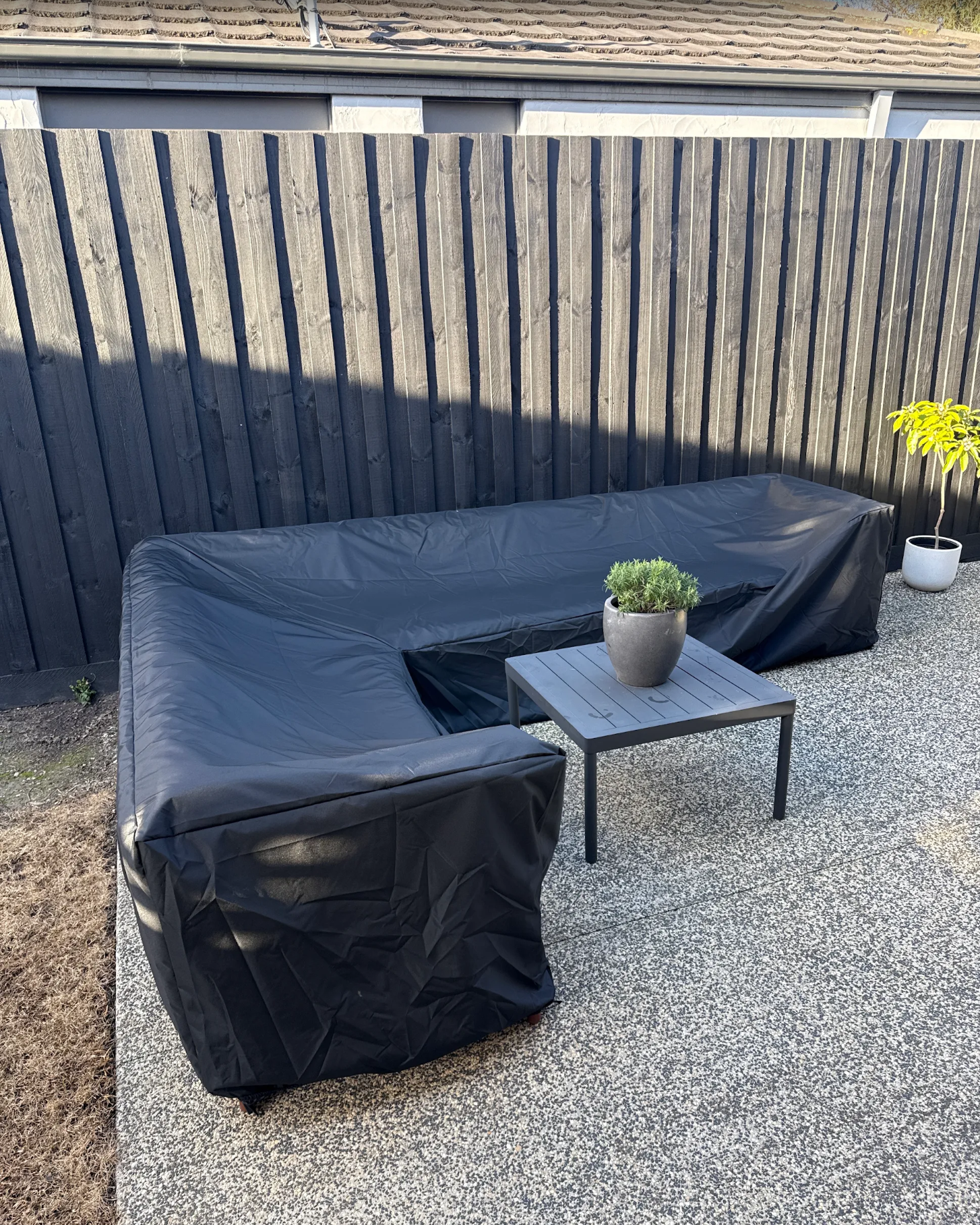 Custom made patio sectional cover in black fitted over an L-shaped patio sectional – The Cover Company USA